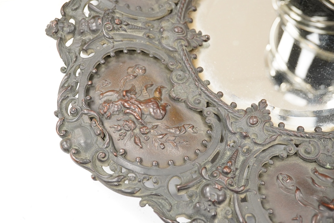 An ornate circular decorative bronzed metal putti decorated wall mirror, 40cm